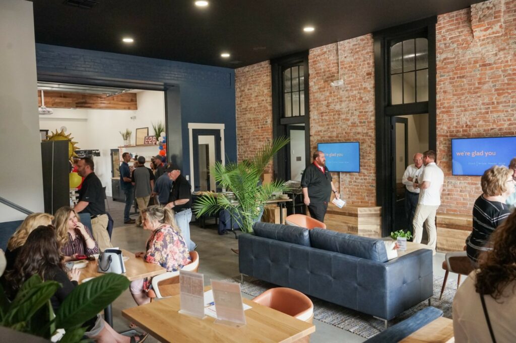 Guests mingling in a chic graduation party venue with exposed brick walls and modern furnishings, creating an inviting atmosphere for celebrating academic achievements.