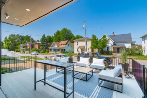 An expansive outdoor deck at a graduation party venue, offering comfortable seating and a view of a serene suburban neighborhood, ideal for hosting an open-air graduation celebration