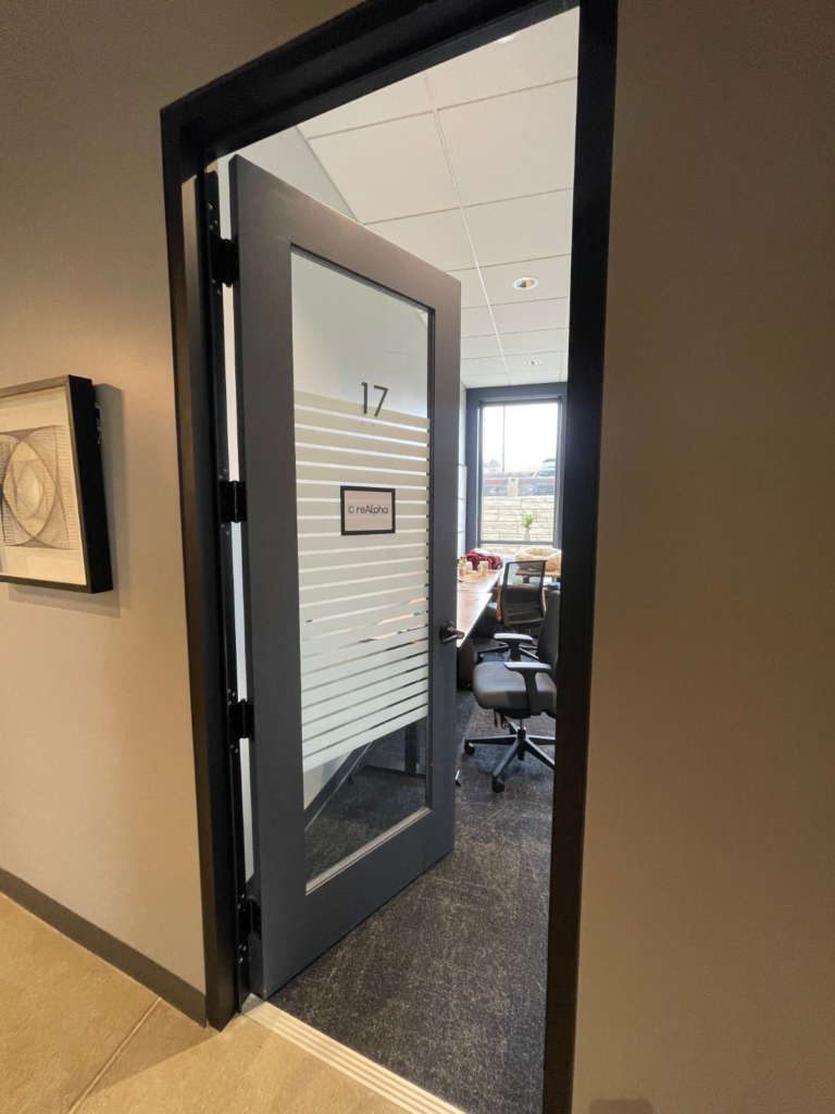 A small office, partially visible through a door labeled