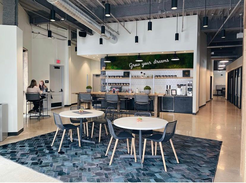 This image shows a break room with a coffee bar and tables for informal meetings, encouraging productivity and collaboration. The open layout offers other benefits by providing space-efficient seating without using entire floors